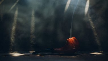 Çelik zemin üzerinde tütün dumanı ve ışık ışınlarıyla tütsülenmiş kiraz ağacı tütsüsü.