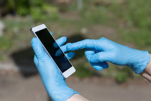 Hombre Sostiene Teléfono Móvil Las Manos Con Guantes Médicos — Foto de Stock