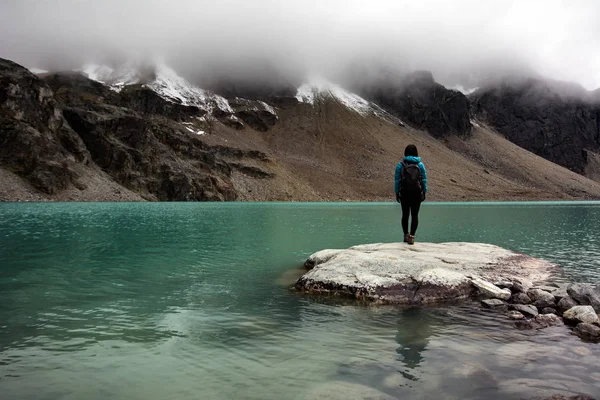 Emale turista stojí na okraji jezera kamenné — Stock fotografie