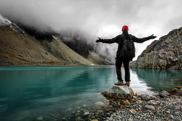 Muž turista stojí na břehu jezera — Stock fotografie