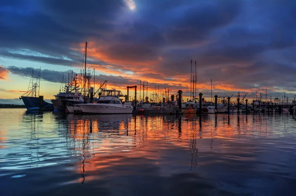 Морський пейзаж з човнами на причалі на заході сонця — стокове фото