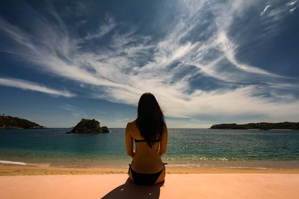 Giovane ragazza seduta sulla spiaggia . — Foto Stock