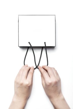 Kağıt alışveriş çantası elinde.