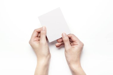 Beyaz bir kartpostal tutarak.