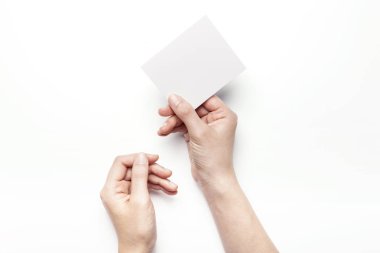 Beyaz bir kartpostal tutarak.