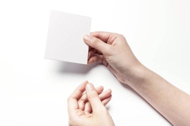 Beyaz bir kartpostal tutarak.