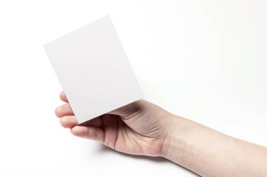 Beyaz bir kartpostal tutarak.