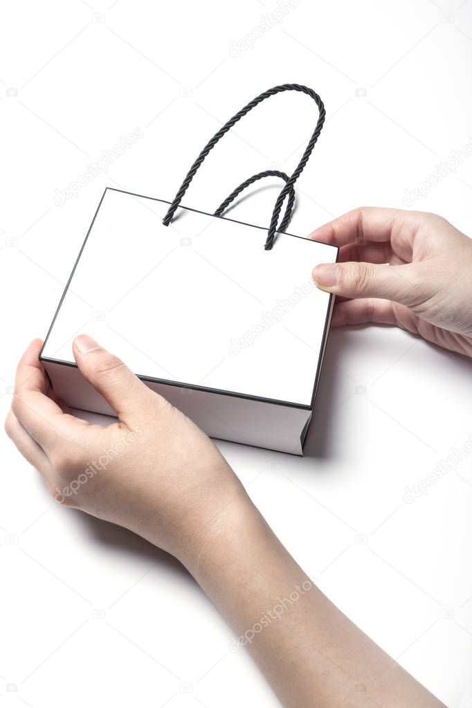 holding a paper shopping bag.