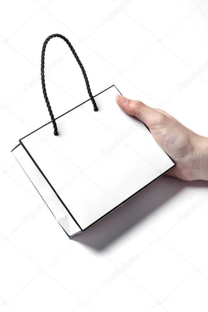 holding a paper shopping bag.