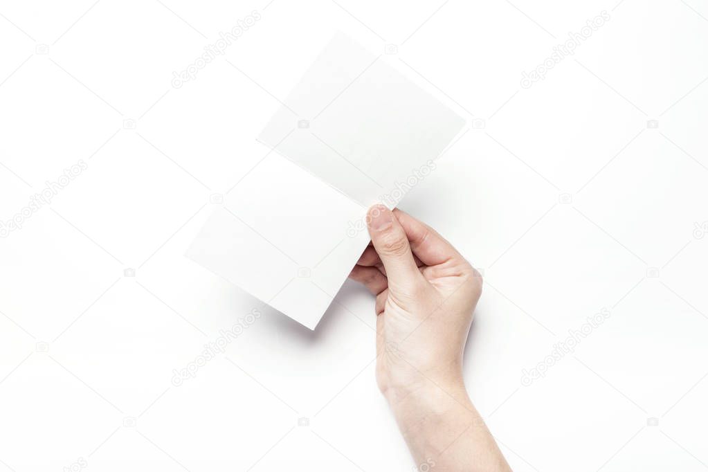 holding a white postcard.