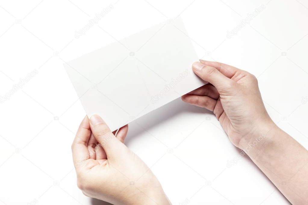 holding a white postcard.