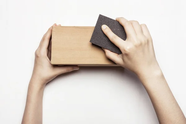 Mujer lijado a mano bloque de madera con papel de lija — Foto de Stock