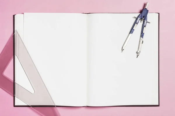 Papelería alrededor del libro sobre fondo rosa — Foto de Stock