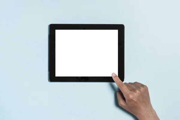 Berühren des Tablet-Computers mit der Hand auf blauem Hintergrund. — Stockfoto