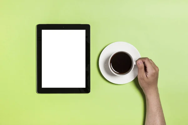 Tablet-Computer mit Kaffee auf grünem Hintergrund. — Stockfoto