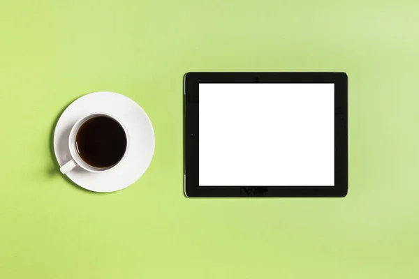 Computador tablet com xícara de café no fundo verde . — Fotografia de Stock