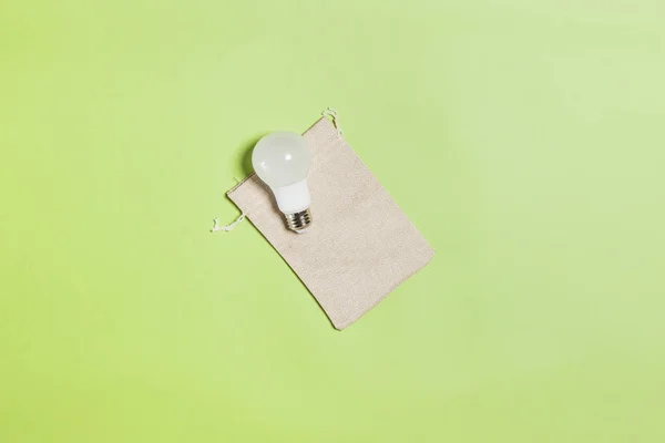 Bulbo con bolsa de lino sobre fondo verde — Foto de Stock