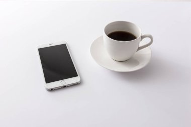 Beyaz arka plan üzerinde kahve ile akıllı telefon. izole.