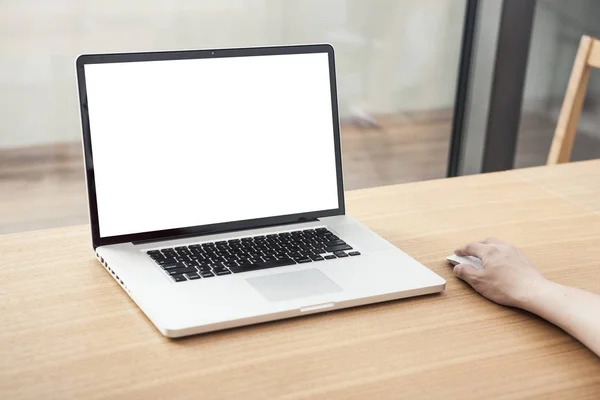 man manipulating a laptop with a mouse on daylight wood desk