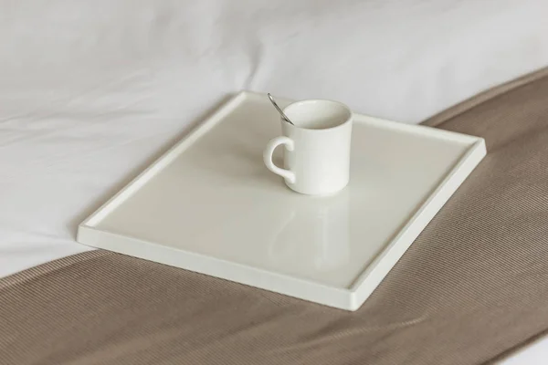 陶瓷杯 茶勺和白床单白色托盘 — 图库照片