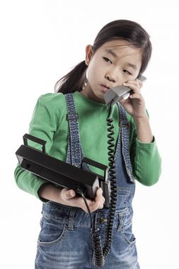 Küçük çocuk retro telefonda konuşuyor.