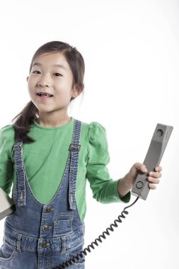 Küçük çocuk retro telefonda konuşuyor.