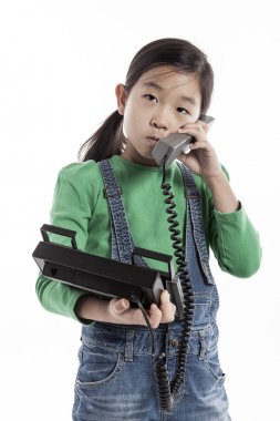 Küçük çocuk retro telefonda konuşuyor.