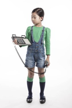 Küçük çocuk retro telefonda konuşuyor.