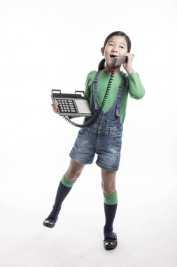 Küçük çocuk retro telefonda konuşuyor.