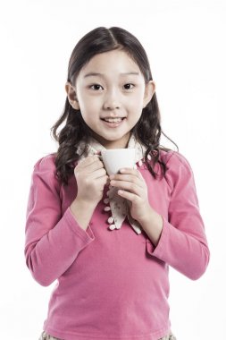 Seramik bardak tutan bir kız. (pembe bluz giyiyor)