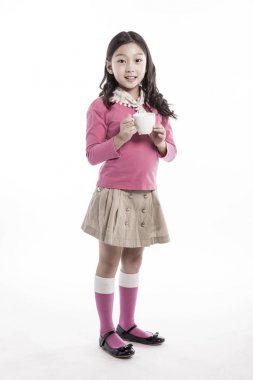 Seramik bardak tutan bir kız. (pembe bluz giyiyor)