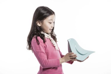 seramik bir kuş tutan bir kız. (pembe bluz giyiyor)