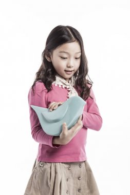 seramik bir kuş tutan bir kız. (pembe bluz giyiyor)