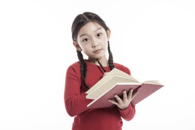Küçük kız beyaz arka plan üzerinde izole stüdyoda bir kitap dururken holding