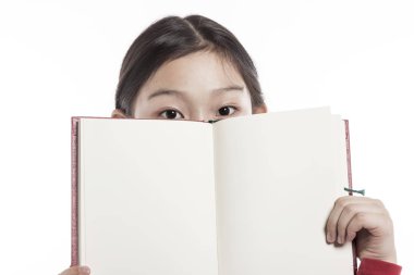 Küçük kız beyaz arka plan üzerinde izole stüdyoda bir kitap dururken holding