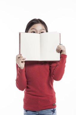 Küçük kız beyaz arka plan üzerinde izole stüdyoda bir kitap dururken holding