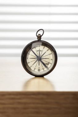 ahşap masa üzerinde antik pusula.