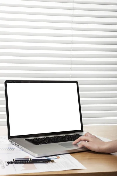 using the laptop on wooden desk.