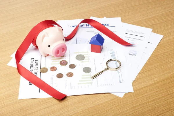 financial concept. housing funds. (piggy bank, document, coins, key, wood block, ribbon)