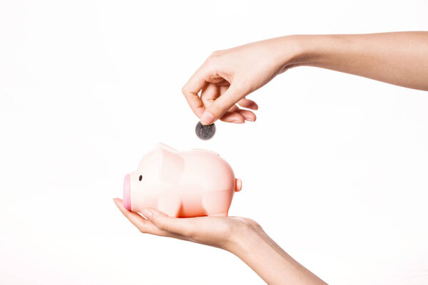 Woman hand hold a piggy bank with coin isolated on white.