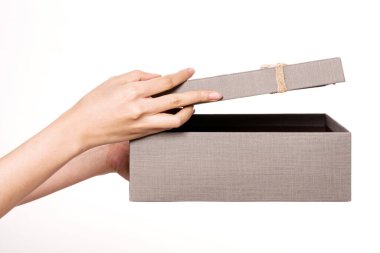 Bir kadın, beyaz bir hediye kutusunu elinde tutuyor.