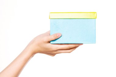 Kadın eli, beyaz bir kutunun üzerinde mavi bir kutu tutuyor..