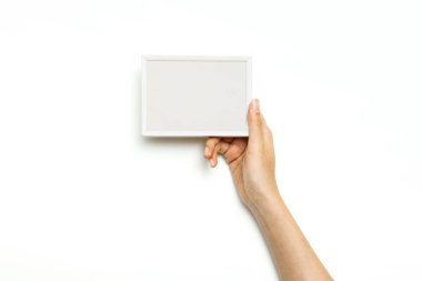 Kadın eli, beyaza izole edilmiş siyah bir hesap makinesi tutuyor..