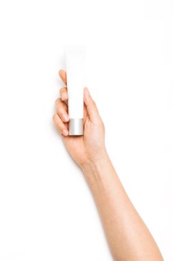 Kadın eli beyaz bir kozmetik konteynırı tutuyor..