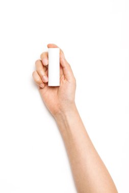 Kadın eli beyaz bir kozmetik konteynırı tutuyor..