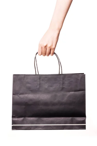 Frauenhand Hält Eine Schwarze Einkaufstasche Isoliert Auf Weißem Grund — Stockfoto