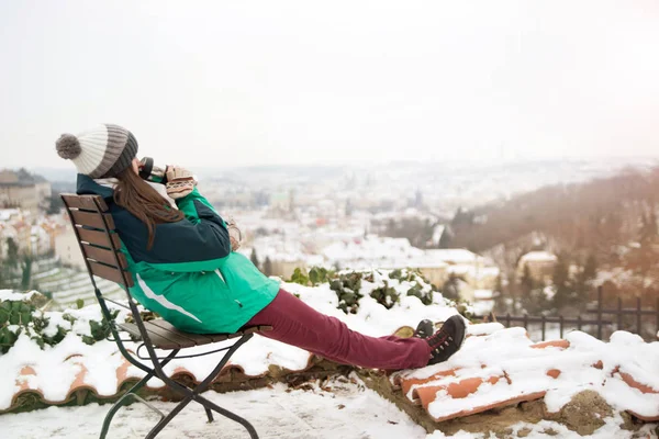 Mädchen sitzt auf Stuhl und trinkt aus Thermobechern — Stockfoto