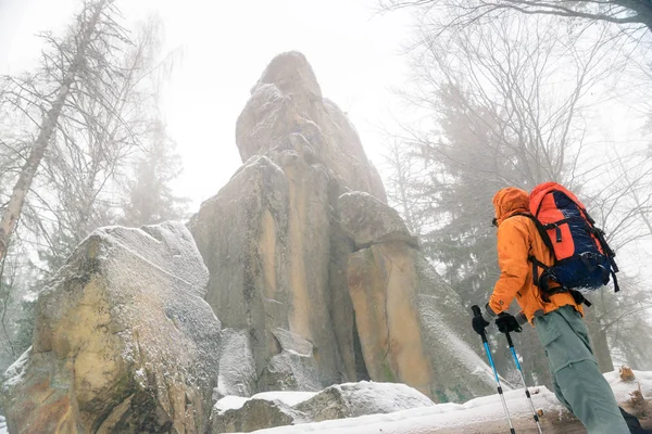 Uomo guardando roccia, luogo selvaggio in montagna, roccia ricoperta di neve — Foto Stock