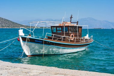 Fishing boat in a blue sea, Elounda coast of Crete island in Greece clipart