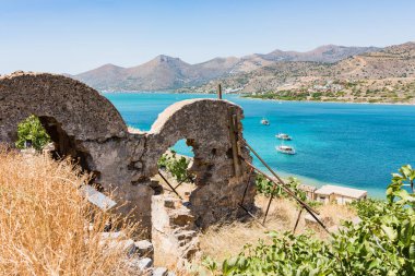 Harabeler Spinalonga üstüne. Mavi deniz ve ada ile dağ pitoresk görünümüne.